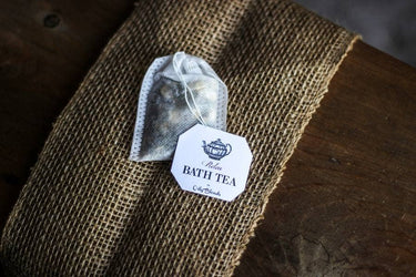Bath Tea Relax product laid on a silk sheet over a wooden surface, showcasing packaging in a soft, neat setting