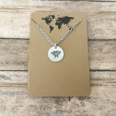 Bee necklace featuring small circular charm with delicate design