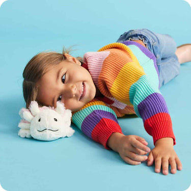 Lifestyle image of Axolotl Warmies Junior plush being used by a child for comforting warmth and play