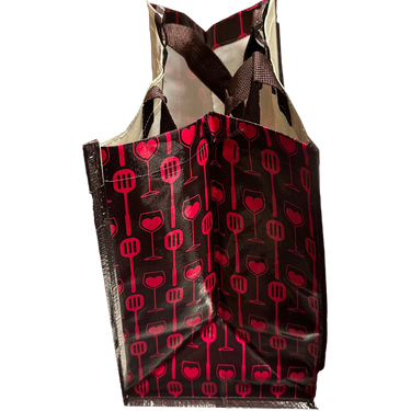 Side view of "Kiss The Cook" grocery bag showing wine glasses and kitchen utensil pattern, specifically spatulas