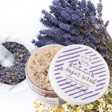 Lavender Blossom Body Sugar Scrub – Organic Lavender Orange shown in a lifestyle setting, half-open to reveal the scrub contents, highlighting product use and natural, relaxing environment