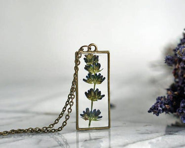 Lavender Pendant Necklace front view in a lifestyle setting, highlighting the pendant design and chain in a natural, real-world environment