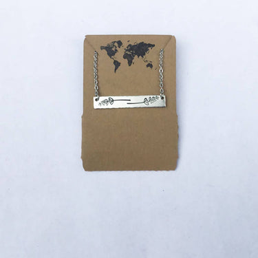 Lavender sprig bar necklace displayed on hang tag, showing design and packaging on a studio background