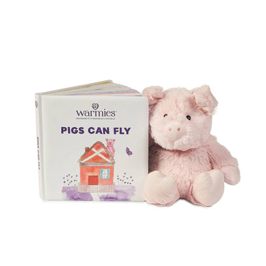Children's board book "Pigs Can Fly" displayed alongside Pig Warmies Junior plush for a gift set or playtime